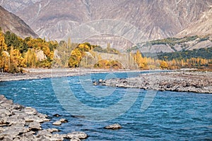 Autumn scene of blue water of Gilgit river flowing through Gupis, Ghizer, Pakistan.