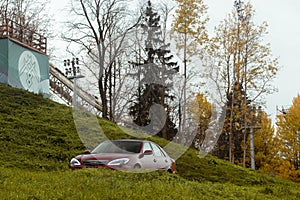 Autumn scene with Cherry red 4 door family d-class sedan Toyota Camry