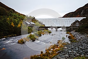 Autumn scene of water flowing over the Caban Coch Dam in Elan Valley