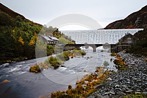 Autumn scene of water flowing over the Caban Coch Dam in Elan Valley photo