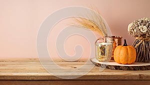 Autumn season concept with pumpkin decor and candle on wooden table. Halloween or Thanksgiving greeting card