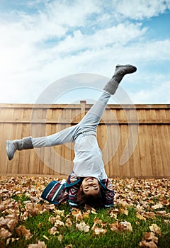 Autumn, the season of fun. an adorable little girl doing cartwheels an autumn day outdoors.