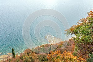 Autumn shore of Lake Garda decorated with colourful trees