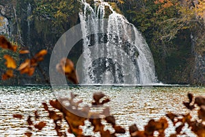 Autumn shot of a waterfall flowing down into a lake in Plitvice Lakes national park