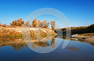Autumn Siberian landscape-a lonely inflatable boat moored on the river bank