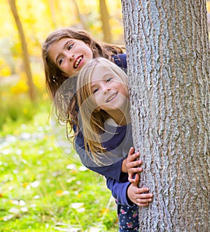 Autumn sister kid girls playing in forest trunk outdoor