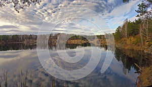 Autumn sky with light clouds over a body of water photo