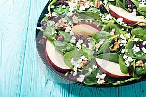 Autumn spinach salad with apple , cheese , walnut and dried cranberry . Healthy vegetarian food