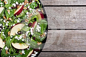 Autumn spinach salad with apple , cheese , walnut and dried cranberry . Healthy vegetarian food