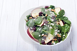 Autumn spinach salad with apple cheese , walnut and dried cranberry . Healthy vegetarian food
