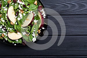 Autumn spinach salad with apple , cheese , walnut and dried cranberry . Healthy vegetarian food