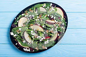 Autumn spinach salad with apple , cheese walnut and dried cranberry . Healthy vegetarian food