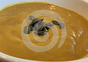 Autumn squash soup garnished with pumpkin seeds