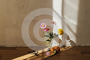 Autumn still life. Autumn flowers composition and scissors in sunny light in modern rustic room