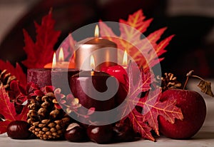 Autumn still life - candles, leaves and cones on the background