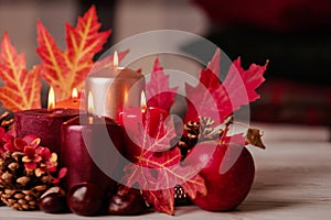 Autumn still life - candles, leaves and cones on the background