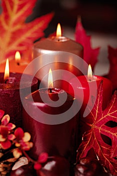 Autumn still life - candles, leaves and cones on the background