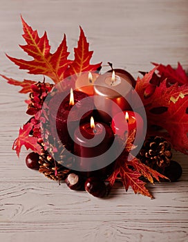 Autumn still life - candles, leaves and cones on the background