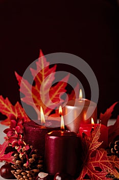 Autumn still life - candles, leaves and cones on the background
