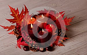 Autumn still life - candles, leaves and cones on the background of pillows