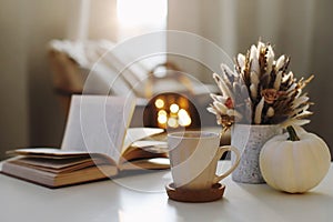 Autumn still life. Coffee cup, flowers, book and pumpkin. Hygge lifestyle, cozy autumn mood. Flat lay, Happy thanksgiving