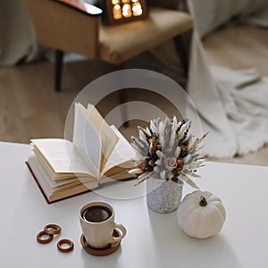 Autumn still life. Coffee cup, flowers, book and pumpkin. Hygge lifestyle, cozy autumn mood. Flat lay, Happy thanksgiving