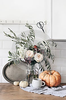 Autumn still life composition. Cup of coffee, vintage silver tray and floral bouquet. Fall kitchen still life with