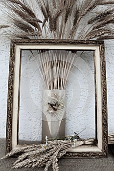 Autumn still life with ears of wheat and rye in a frame from a picture