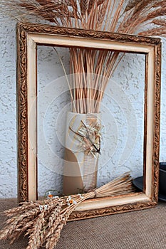 Autumn still life with ears of wheat and rye in a frame from a picture