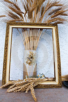 Autumn still life with ears of wheat and rye in a frame from a picture