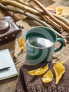 Autumn still-life. Enameled mug, old camera, Notepad, pencil