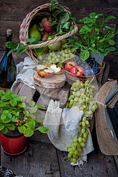 Autumn still life. Fruits and berries. Apples, grapes, strawberries, plums on a wooden table. Country style. Idle healthy vitamin