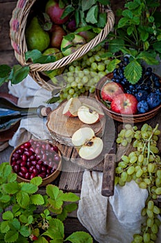 Autumn still life. Fruits and berries. Apples, grapes, strawberries, plums on a wooden table. Country style. Idle healthy vitamin