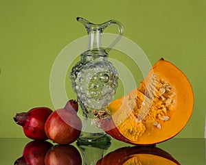Autumn still life with pumpkin and two pomegranate.