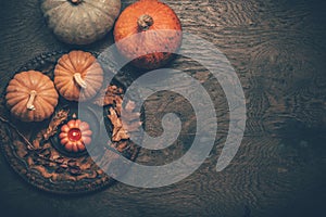 Autumn still life with pumpkins and candles on wooden background. Thanksgiving home decoration