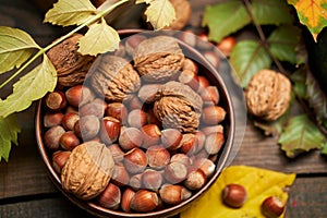 Autumn still life in rustic style as a background - leaves, vegetables and fruits, nuts and other natural food ingredients on