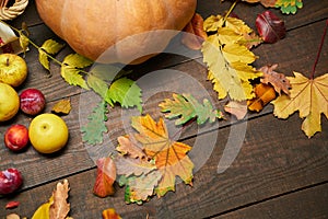 Autumn still life in rustic style as a background - leaves, vegetables and fruits, nuts and other natural food ingredients on