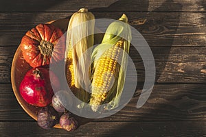 Autumn still life in rustic style with  pumpkin and corn, pomegranate and figs