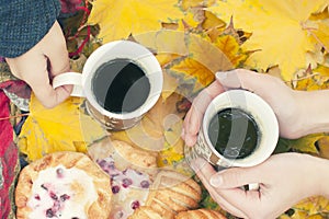 Autumn still life, two mugs with tea in hands, cakes, picnic in autumn park