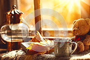 Autumn still life. A window, hot tea mug book