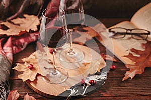 Autumn still life with wine, book and dry leaves