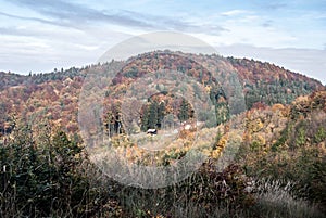 Jesenné Súľovské skaly na Slovensku s kopcom s farebným lesom a chatou na malej lúke