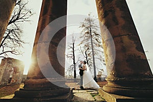 Autumn sun shines above a weddding couple which stands between o