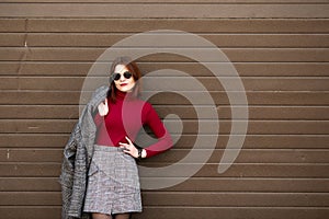 Autumn sunny lifestyle fashion portrait of young stylish hipster woman walking on the street.