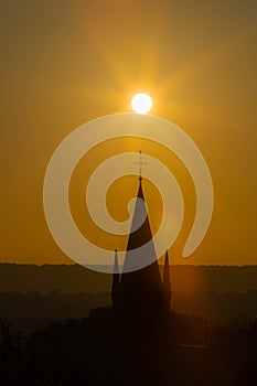 An autumn sunrise in Maastricht with in silhouette the tower of the church of Sint Pieter