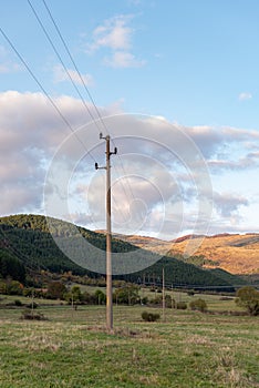 Autumn sunset orange green vibrant landscape rural power lines clouds blue sky hillside forest trees beautiful bulgaria