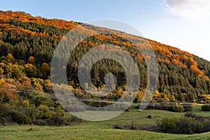 Autumn sunset orange green vibrant landscape rural power lines clouds blue sky hillside forest trees beautiful bulgaria