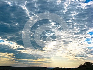 Autumn sunset. The sun`s rays of the evening sun break through the clouds against the blue sky