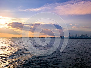 Autumn sunset view across Toronto Harbour of Lake Ontario with foggy Downtown Toronto skyline in background under deep