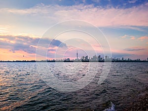 Autumn sunset view across Toronto Harbour of Lake Ontario with foggy Downtown Toronto skyline in background under deep